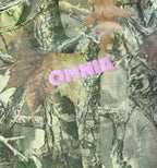 Close-up of the pink OMNIA chest logo on camo