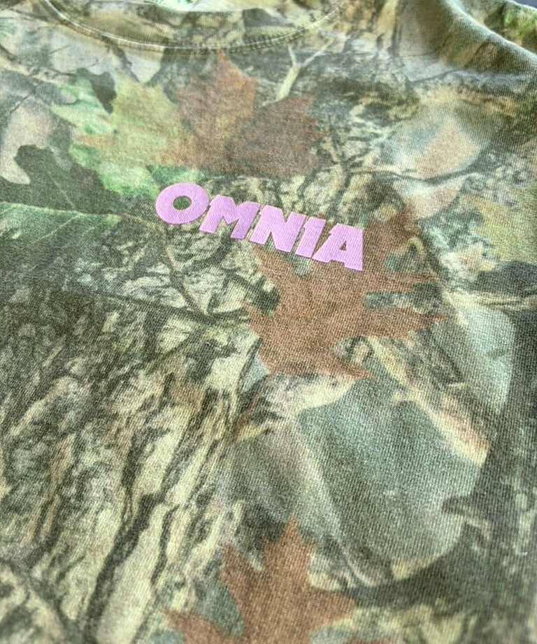 Close-up of the pink OMNIA chest logo on camo